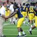 Michigan junior quarterback Denard Robinson reaches after director of strength and conditioning Aaron Wellman as they goof around on the field during media day at Michigan Stadium on Sunday.  Melanie Maxwell | AnnArbor.com